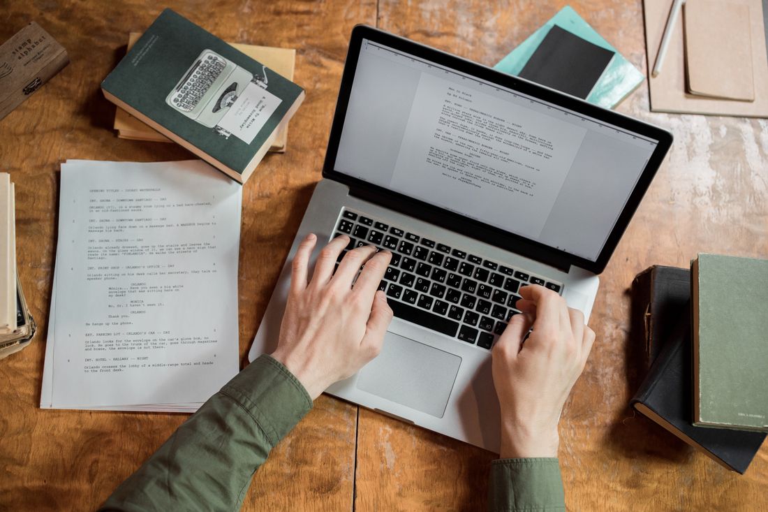 A manuscript, notes and laptop on an editor's desk